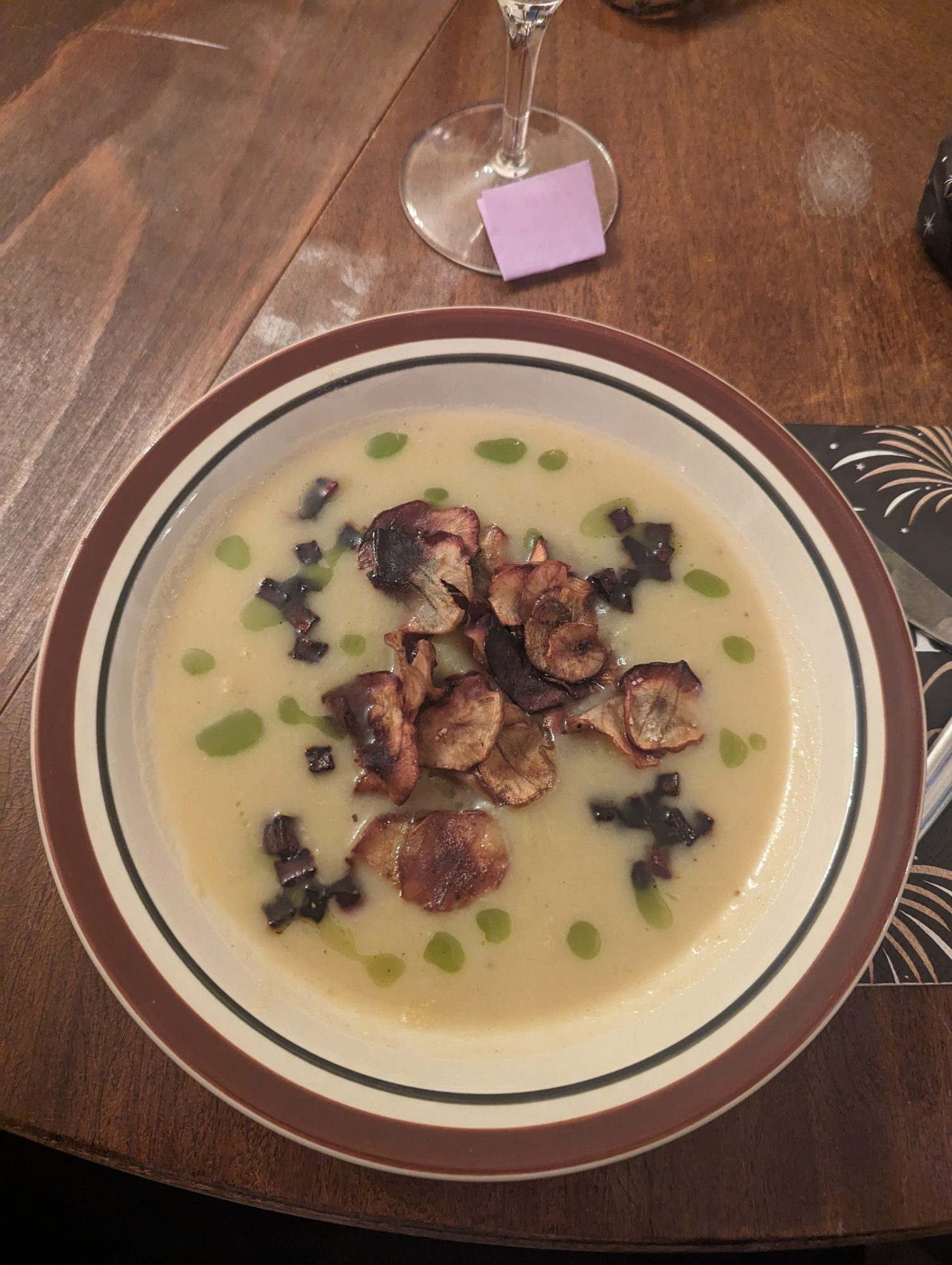 A home-cooked creamy soup with crisps and herb oil