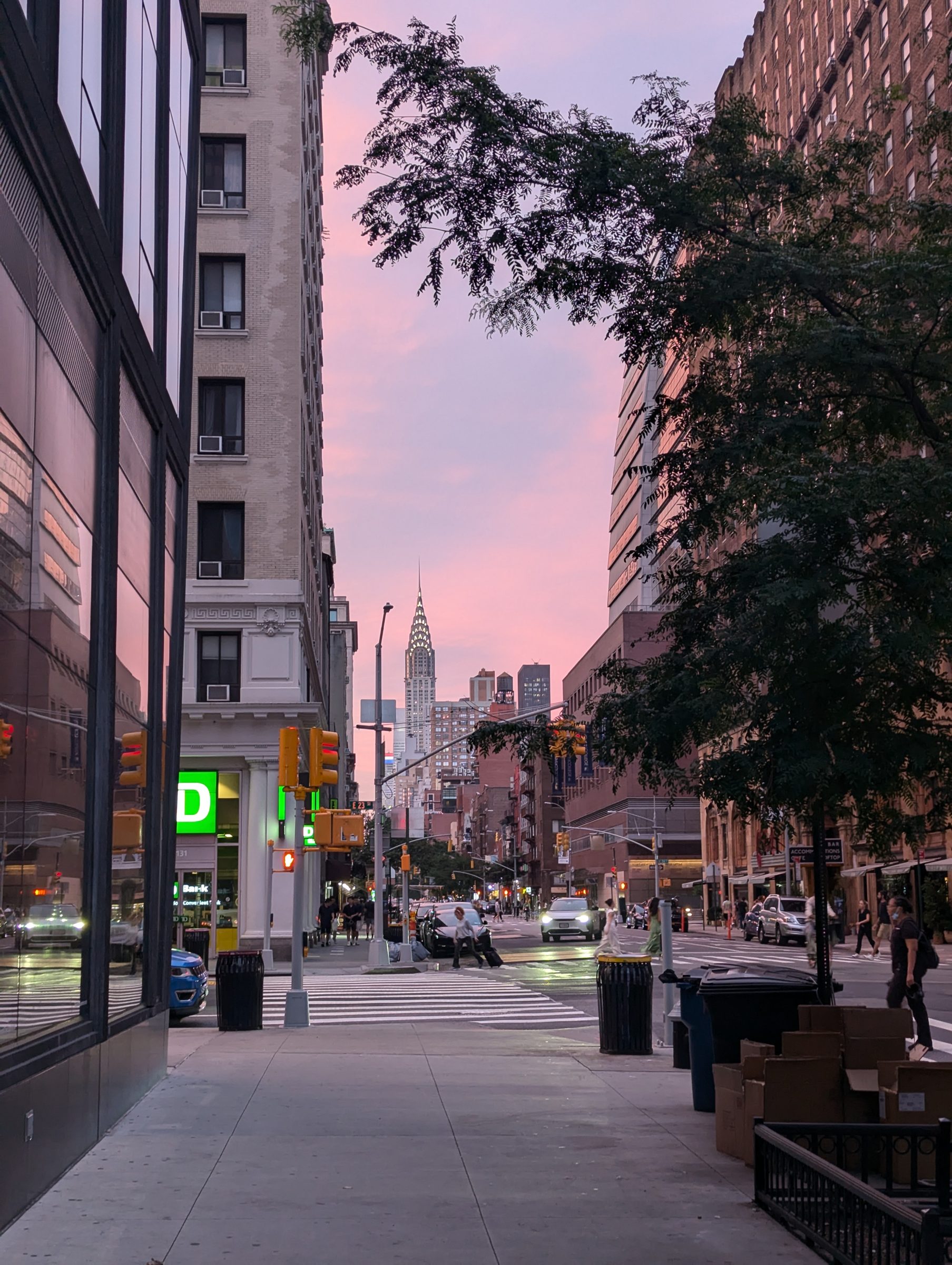 A Manhattan street at dusk with the Chrysler Building beyond